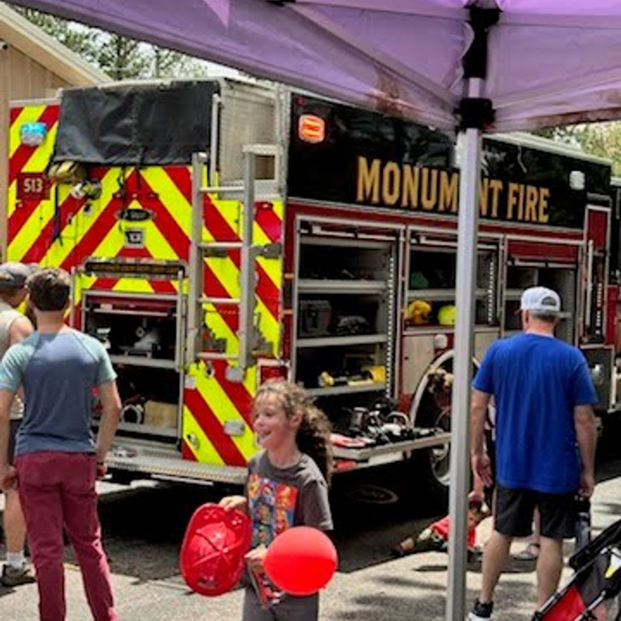 young girl holding a balloon at the Monument fire truck